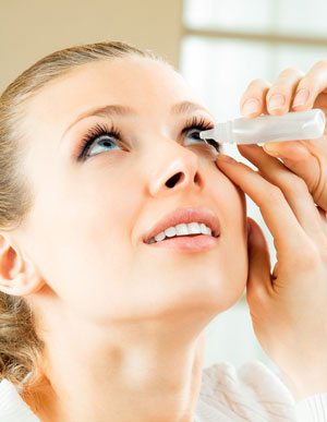 Woman treating her dry eyes with eyedrops
