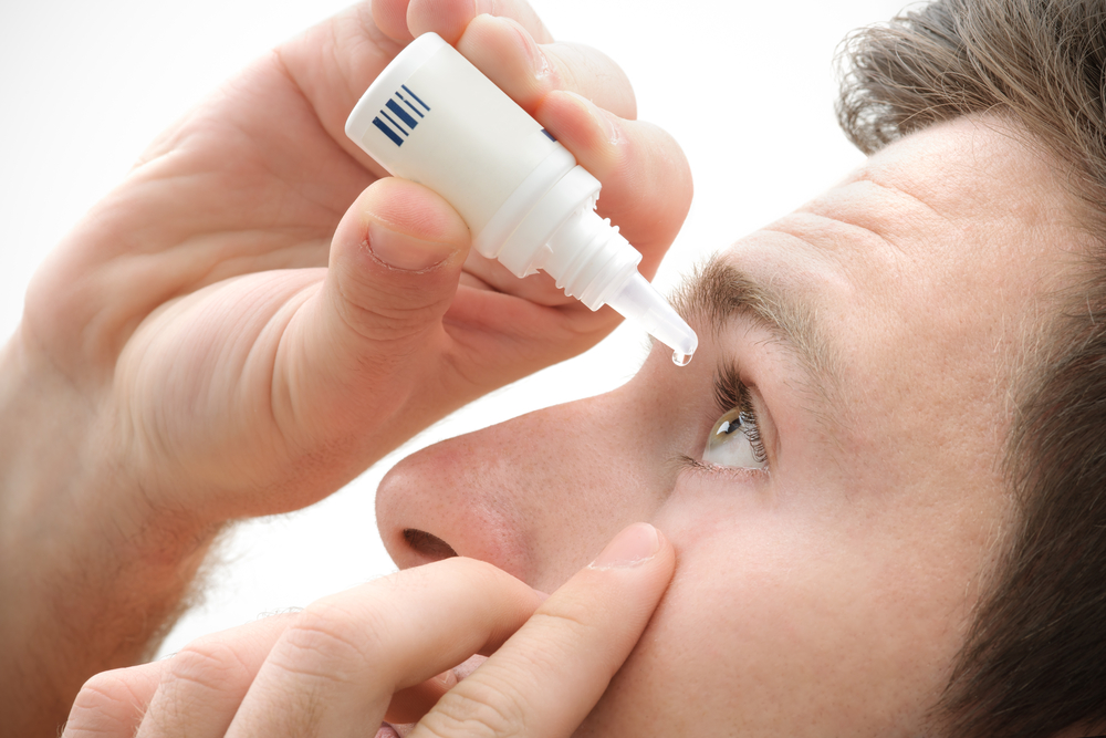 Man using eyedrops for eye allergies